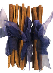 Cinnamon sticks with blue ribbons on a white background