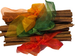 Stack of cinnamon sticks with colorful ribbons on a white background