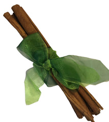 Bunch of cinnamon sticks tied with a green ribbon on a white background