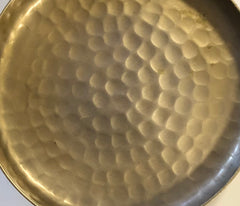 Close-up of a gold-colored metal plate with a textured surface.