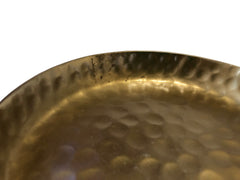 Close-up of a textured gold pan on a white background
